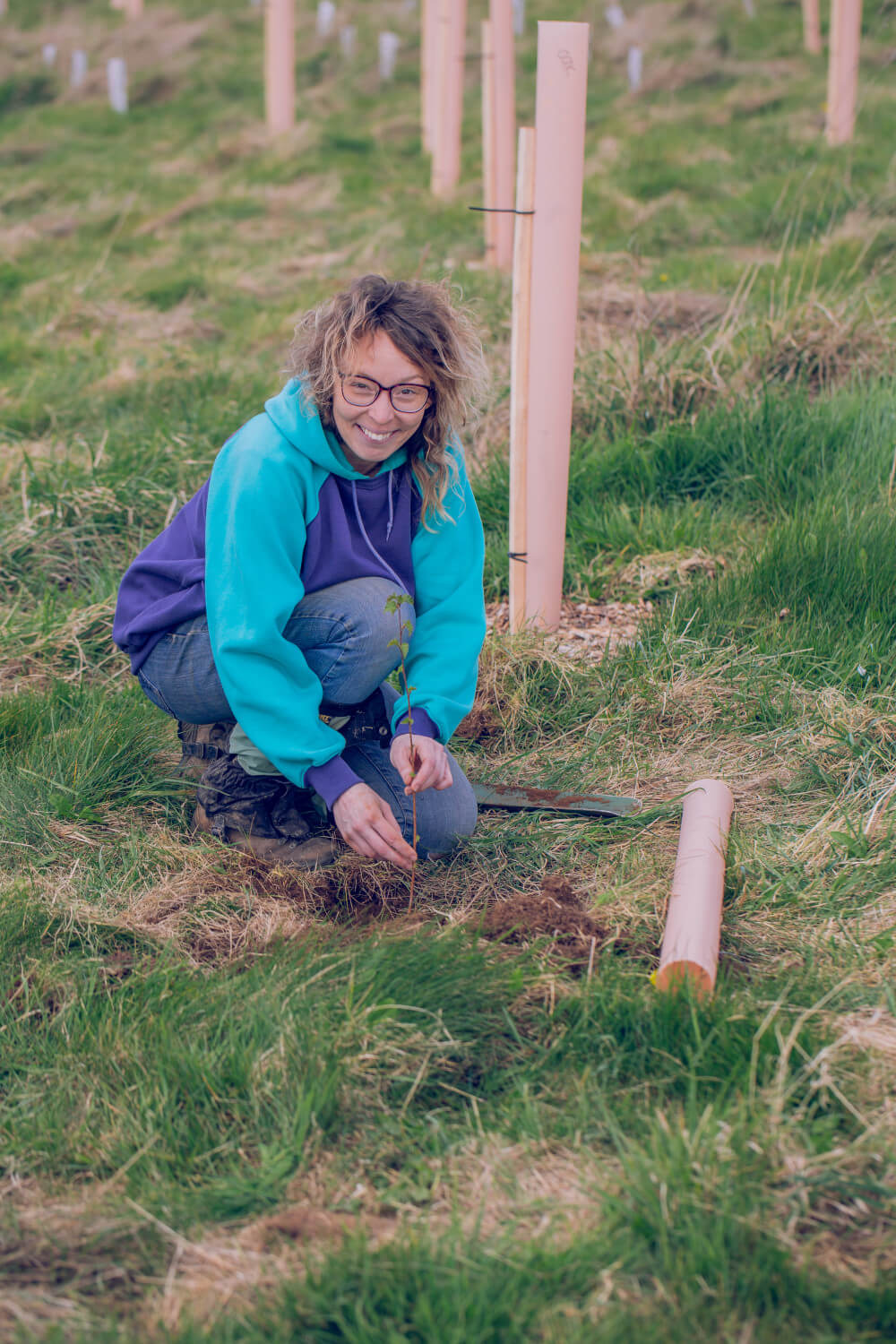 Smiling volunteer planting a tree at Hazeland
