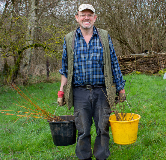 Volunteer leader holding buckets full of sapling