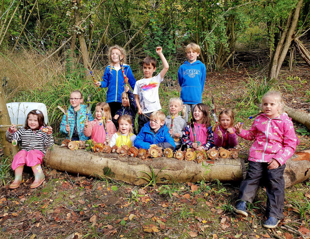 Children at Hazeland Forest School Day with their 'leaf hedgehogs' and woodland wands