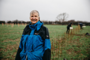 Smiling volunteer at a hedge planting day